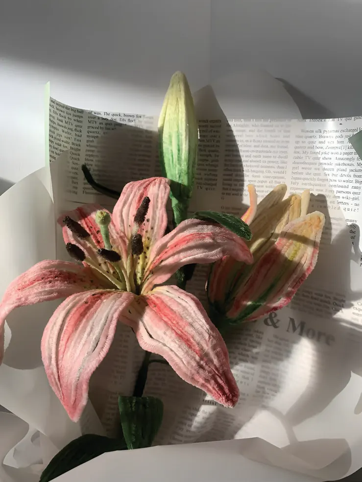 A pink lily bouquet wrapped in printed paper