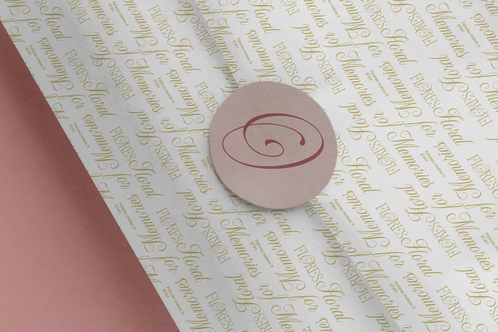 Wrapping paper patterned with Floral for Memories in khaki script, sealed with a blush monogram sticker